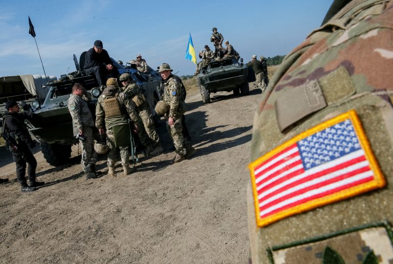 A military instructor of the U.S. Army is seen near Ukrainian servicemen during multinational drills "Rapid Trident 2019" at the International Peacekeeping and Security Center near Lviv